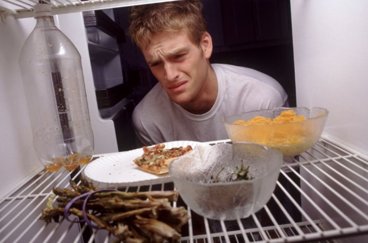 Неприятный запах на кухне. Испорченная еда. Испорченная еда в холодильнике. Протухшая еда в холодильнике. Мужчина готовит.